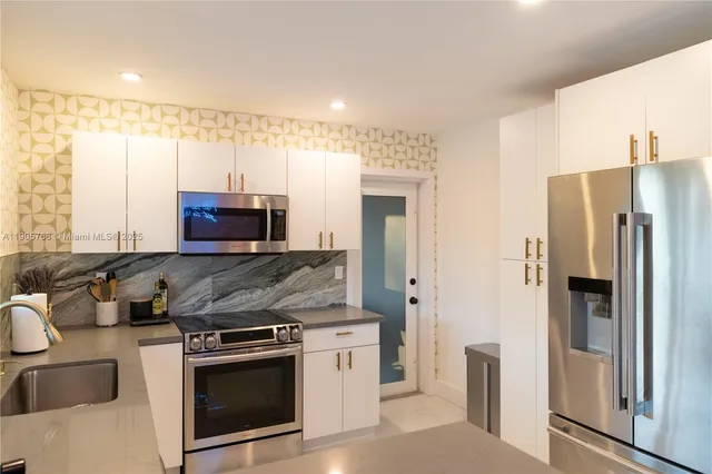 a kitchen with stainless steel appliances granite countertop a refrigerator and a sink