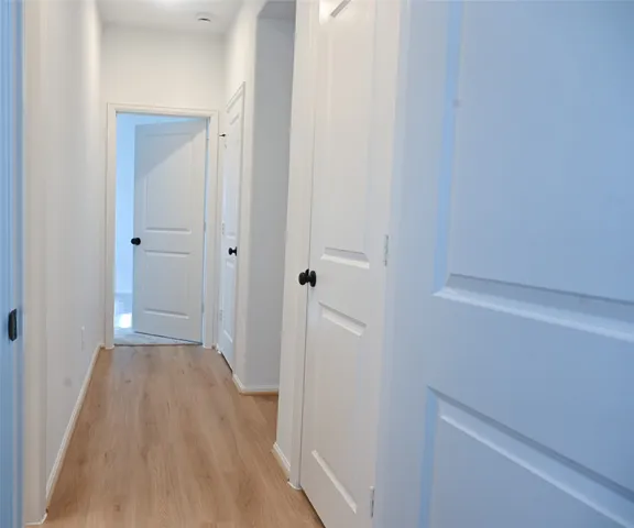 a view of a hallway with wooden floor