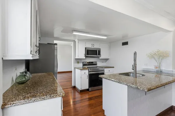 a kitchen with stainless steel appliances granite countertop a sink stove and refrigerator