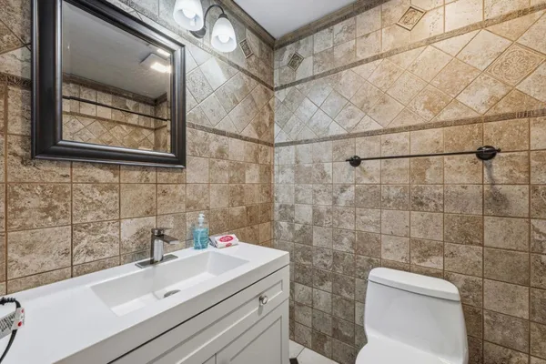 a bathroom with a sink and mirror with toilet