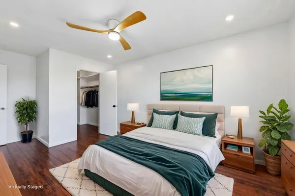 a bedroom with a bed and a potted plant