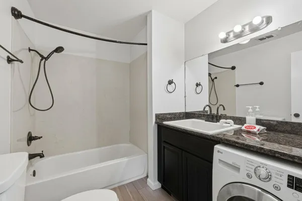 a bathroom with a granite countertop sink mirror and a bathtub