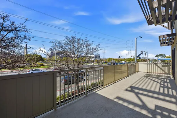 a view of a balcony with wooden floor and iron fence