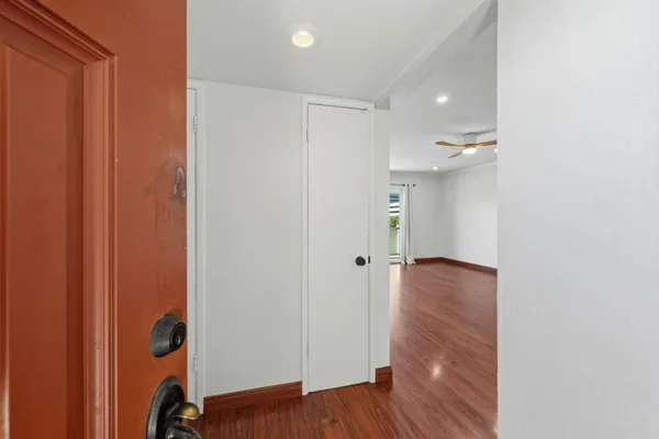 a view of a hallway with wooden floor