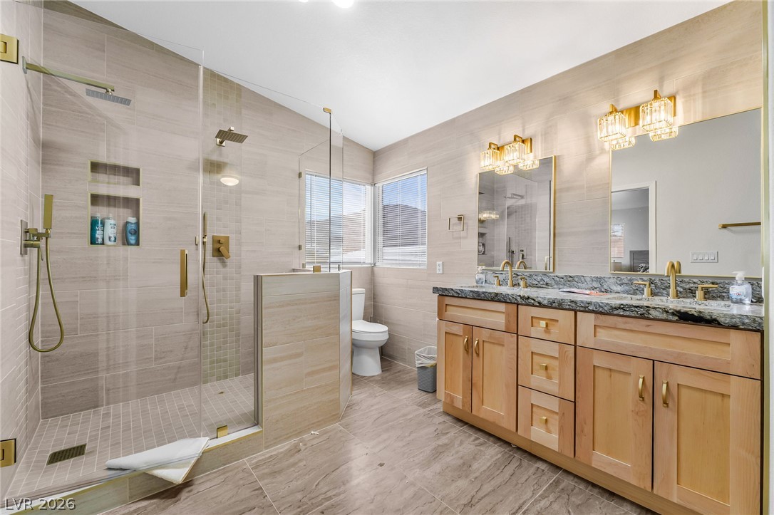 104 Appian Way Henderson, NV 89002 - Photo 17 of 24 A well-lit primary bathroom featuring a spacious walk-in shower and dual vanity.
