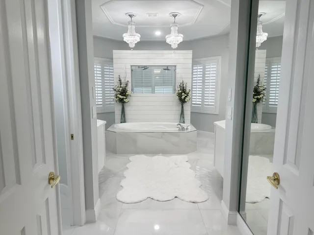 a bathroom with a tub a double vanity sink and a mirror