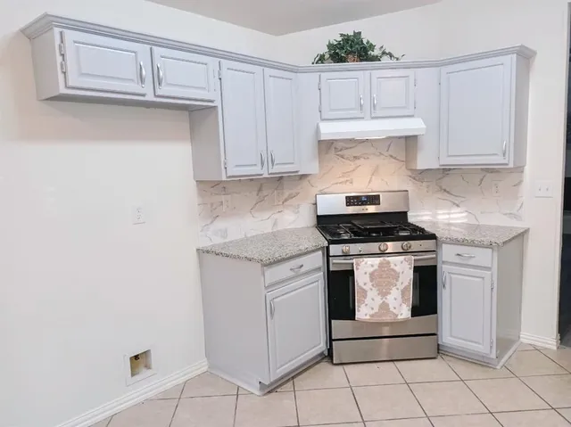 a kitchen with granite countertop white cabinets and white appliances