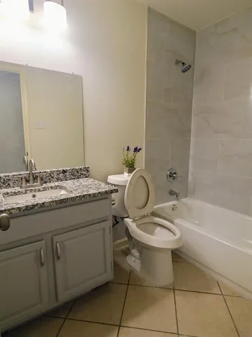 an empty room with wooden floor cabinet and windows