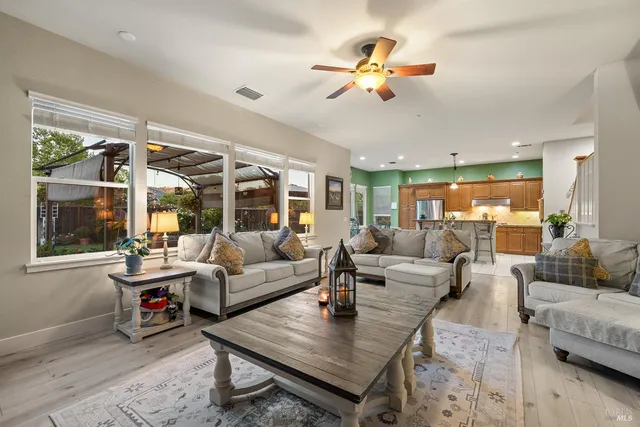 a spacious bedroom with a bed a dresser and flat screen tv