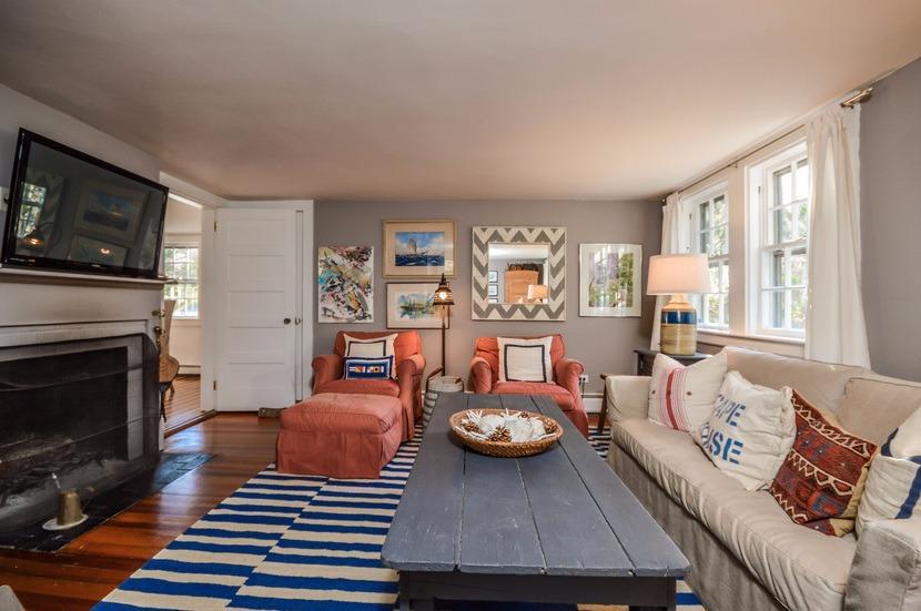 59 Lewis Pond Road Cotuit, MA 02635 - Photo 11 of 24 a living room with furniture a flat screen tv and a fireplace