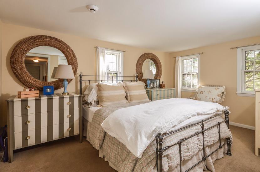 59 Lewis Pond Road Cotuit, MA 02635 - Photo 14 of 24 a bedroom with bed a mirror and a window