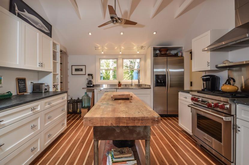 59 Lewis Pond Road Cotuit, MA 02635 - Photo 9 of 24 a kitchen with stainless steel appliances a stove a sink dishwasher a refrigerator white cabinets and wooden floor