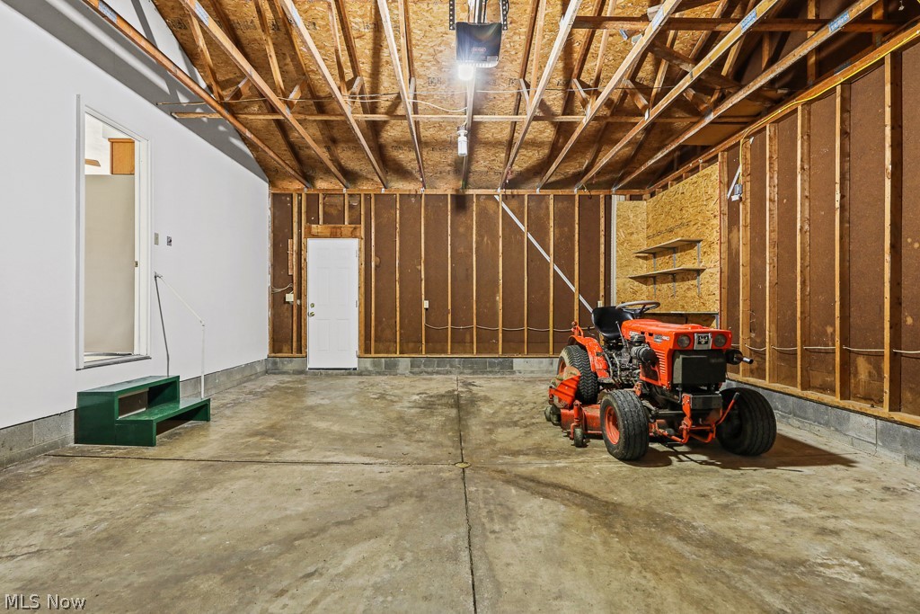 2642 Blake Road Wadsworth, OH 44281 - Photo 44 of 46 Spacious garage with exposed wood ceiling beams, concrete flooring, and built-in shelving