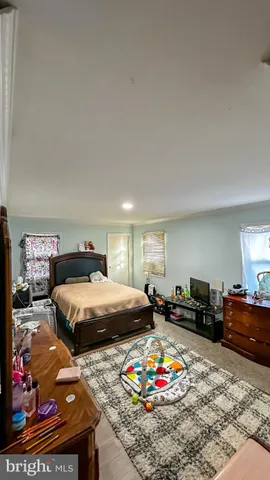 a bedroom that has a bed window and dresser