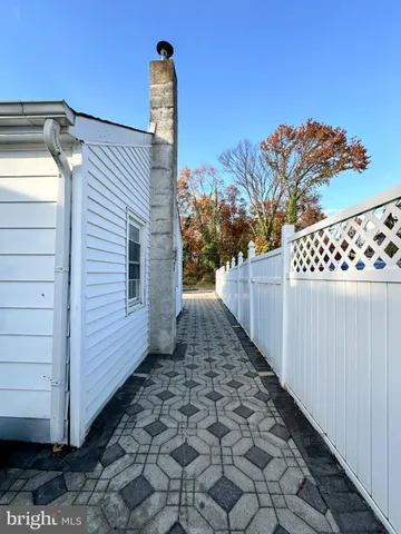 a view of a pathway of a house with wooden fence