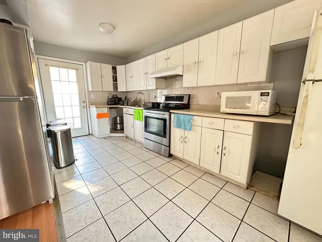 a kitchen with stainless steel appliances a refrigerator sink and microwave