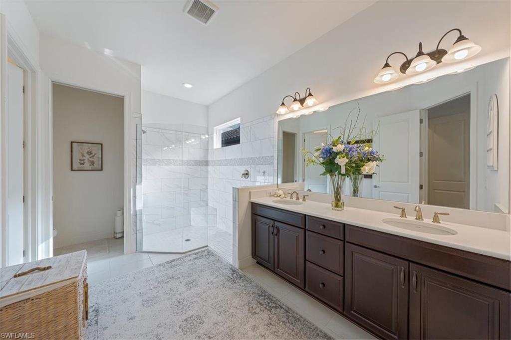 23734 Pebble Pointe Lane Estero, FL 34135 - Photo 15 of 34 a bathroom with a double vanity sink mirror and shower