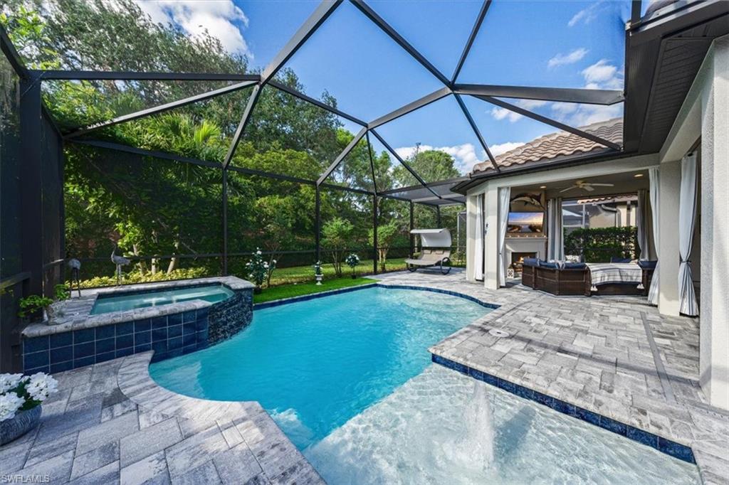 23734 Pebble Pointe Lane Estero, FL 34135 - Photo 28 of 34 a view of a backyard with table and chairs under an umbrella