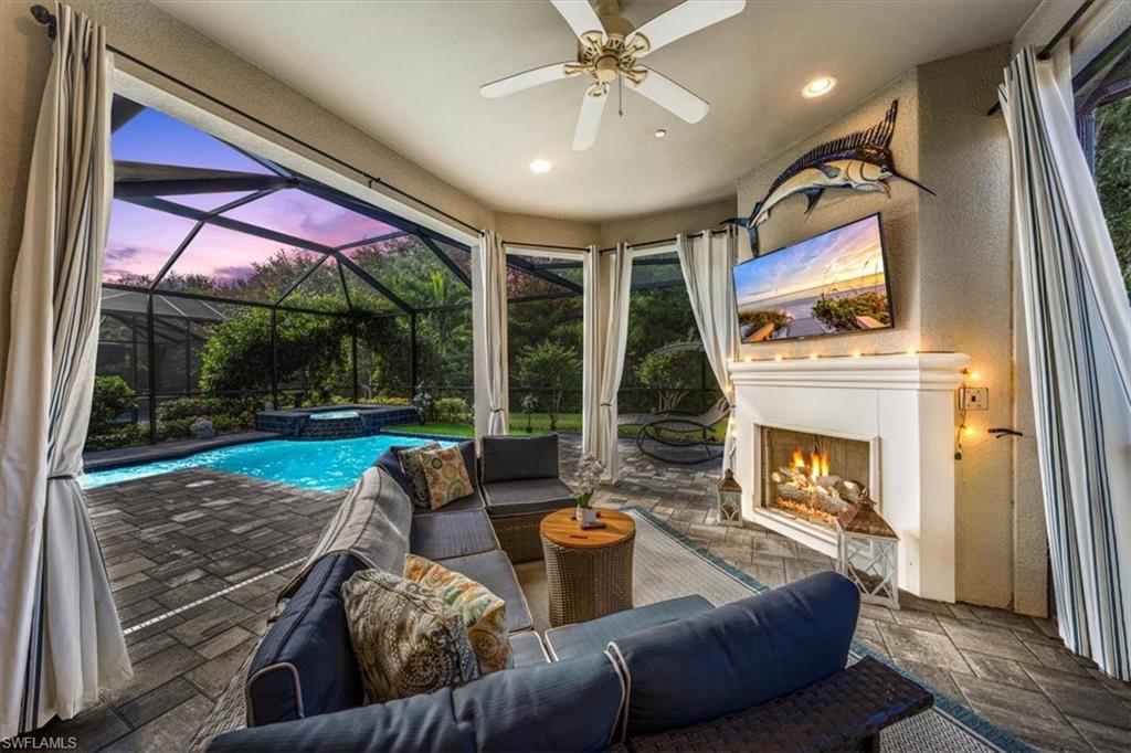 23734 Pebble Pointe Lane Estero, FL 34135 - Photo 34 of 34 a living room with furniture a large window and a fireplace