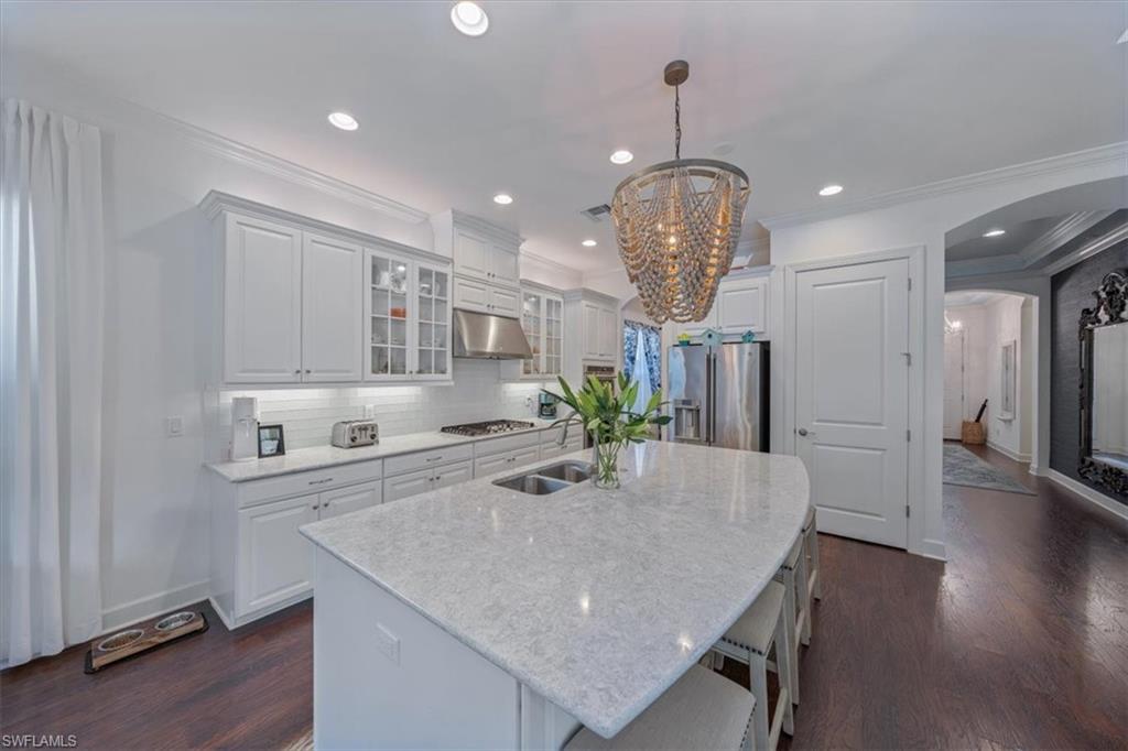 23734 Pebble Pointe Lane Estero, FL 34135 - Photo 9 of 34 a kitchen with stainless steel appliances granite countertop a table chairs and wooden floor