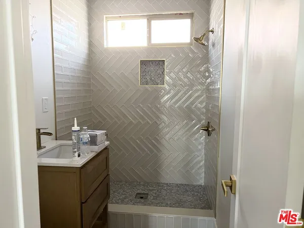 a bathroom with a shower sink and mirror