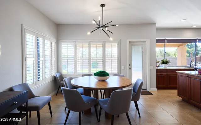 a dining room with furniture a chandelier and wooden floor