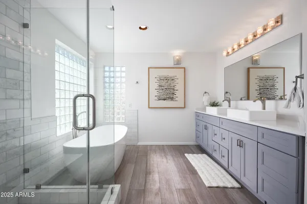 a spacious bathroom with a double vanity sink a mirror and a shower