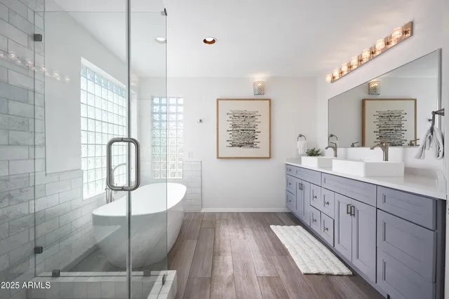 a spacious bathroom with a double vanity sink a mirror and a shower