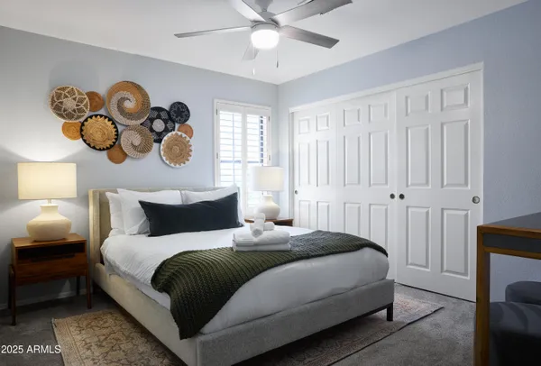 a bedroom with a bed and painting on the wall