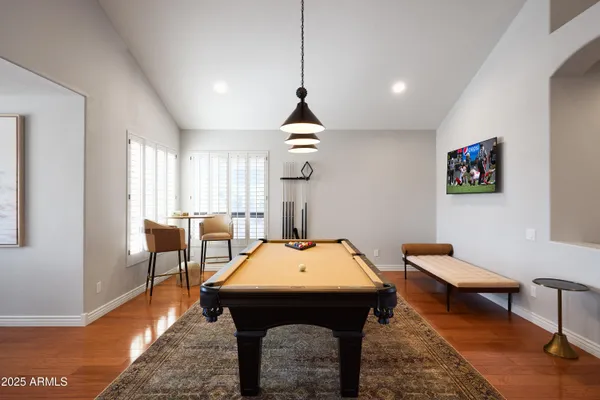 a room with furniture pool table and windows