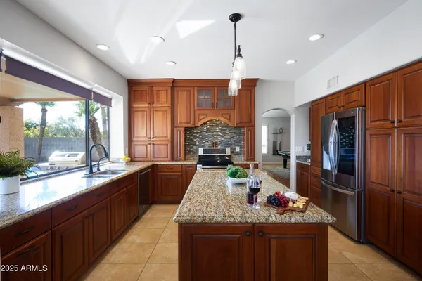 a large kitchen with kitchen island granite countertop a large counter top and stainless steel appliances