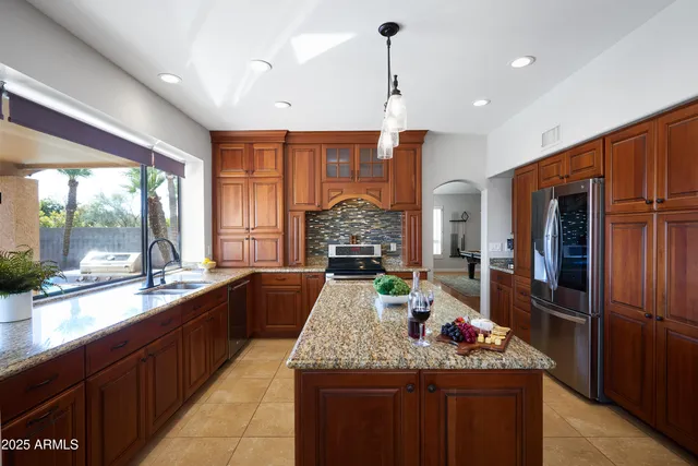 a large kitchen with kitchen island granite countertop a large counter top and stainless steel appliances