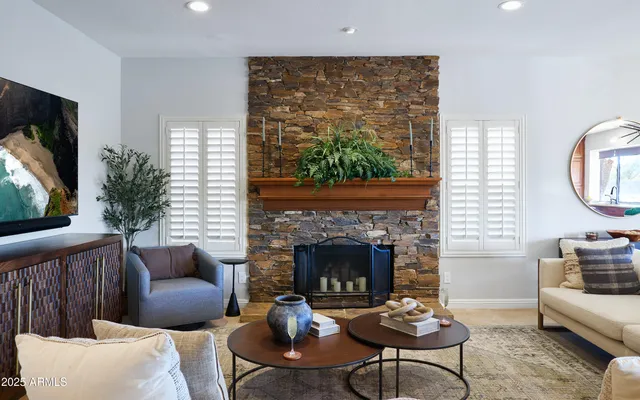 a living room with furniture a fireplace a flat screen tv and a large window