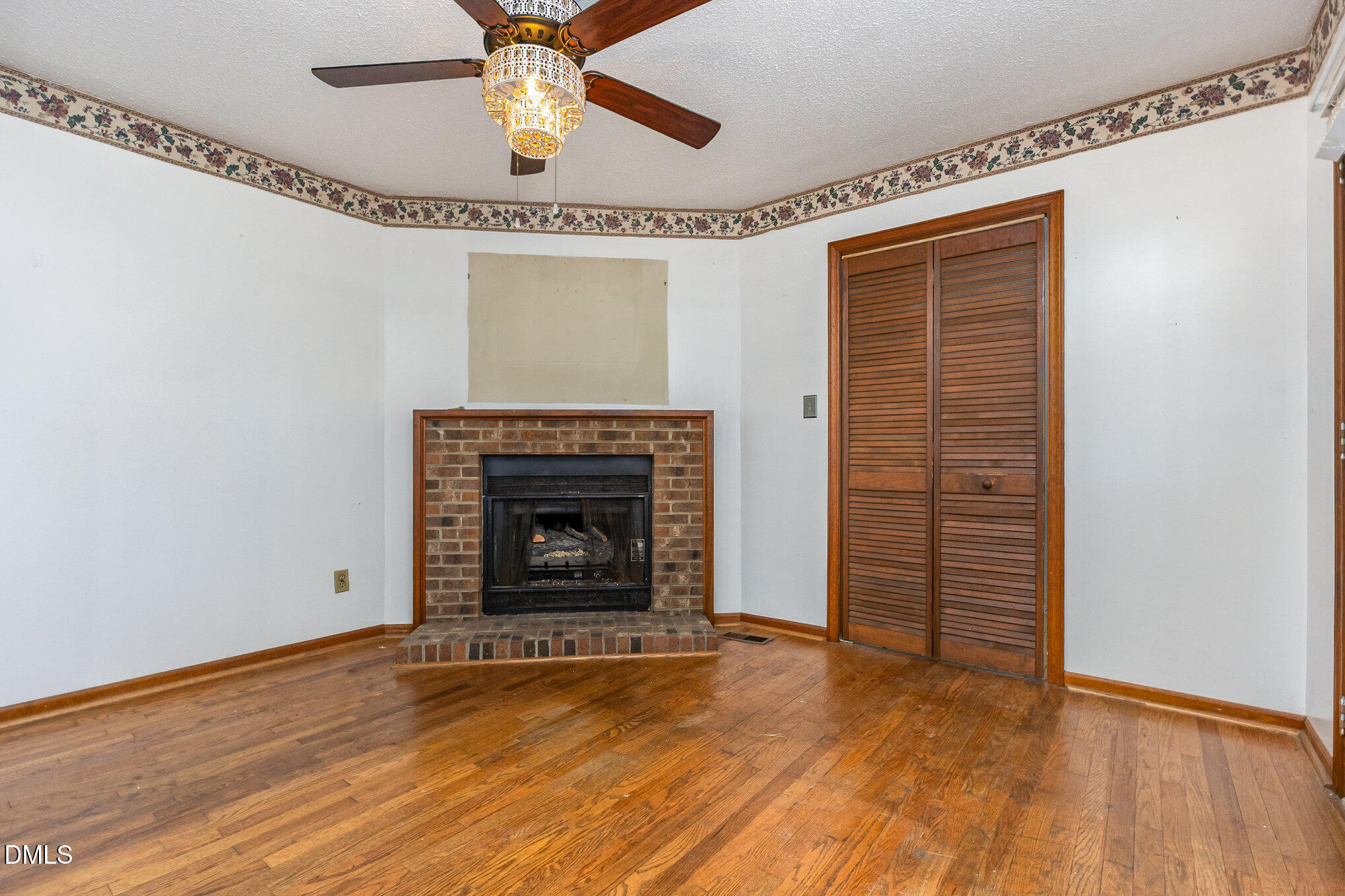 2111 Fieldcrest Road East Wilson, NC 27893 - Photo 8 of 37 a view of an empty room with wooden floor a fireplace and a window