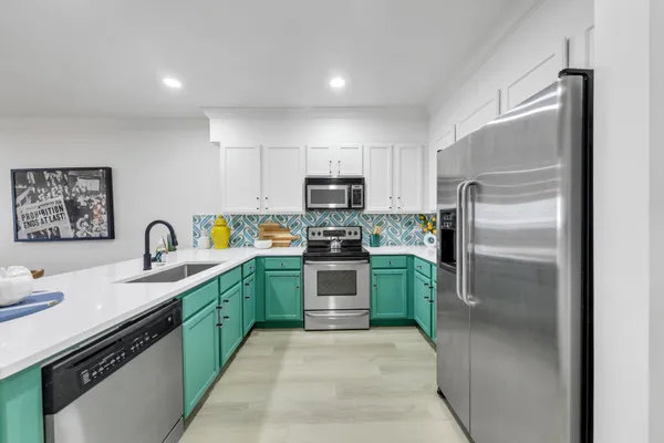 a kitchen with stainless steel appliances granite countertop a refrigerator and a sink