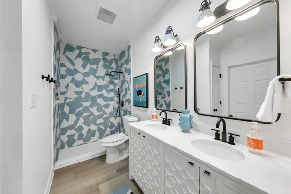 a bathroom with a double vanity sink mirror and toilet