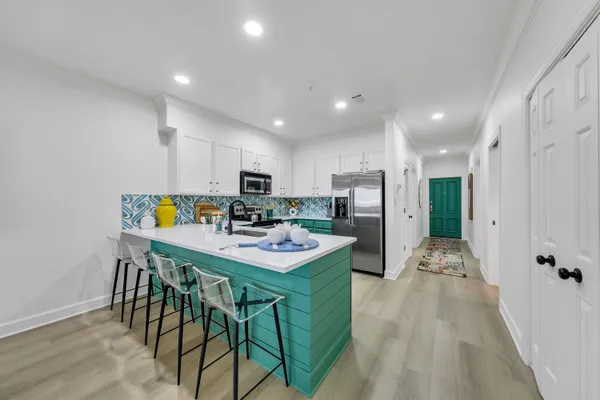 a kitchen with stainless steel appliances kitchen island granite countertop a refrigerator and a stove top oven