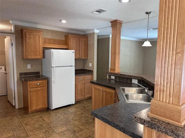 a kitchen with granite countertop a refrigerator a stove and a sink