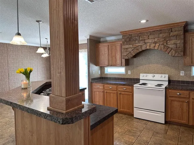 a kitchen with kitchen island granite countertop a sink stainless steel appliances and cabinets