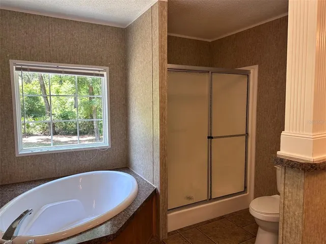 a bathroom with a tub toilet and window