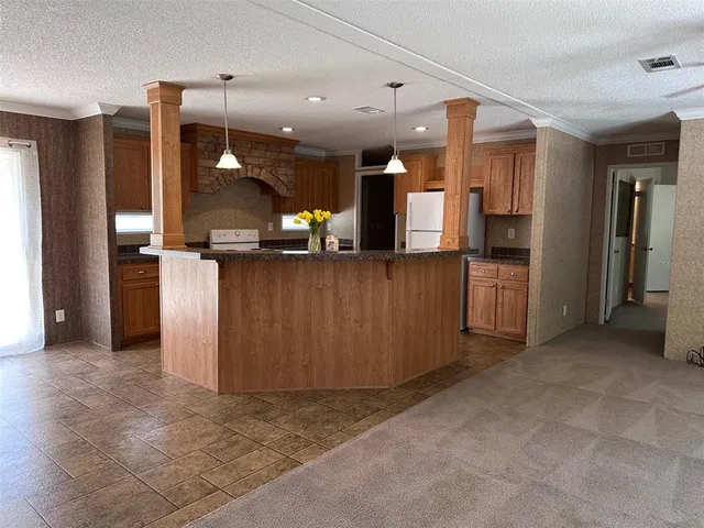 an empty room with a kitchen view and a window