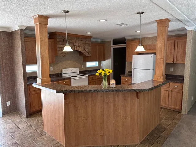 a kitchen with stainless steel appliances granite countertop a refrigerator a sink and a stove