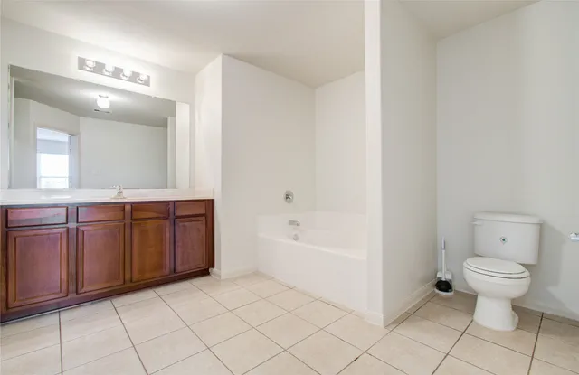 a spacious bathroom with a bathtub sink and mirror