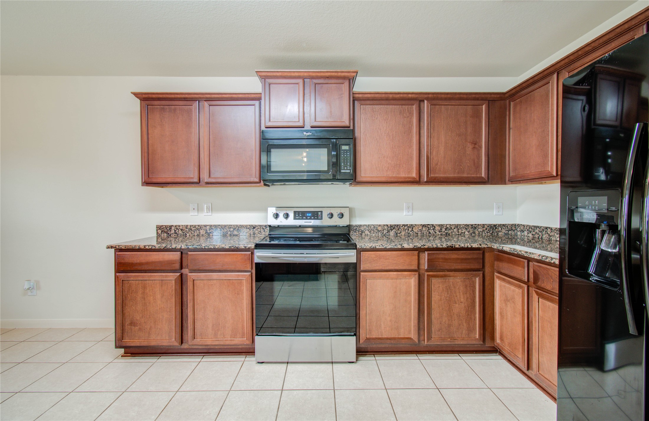 8218 Hall View Drive Houston, TX 77075 - Photo 10 of 31 a kitchen with granite countertop a stove top oven microwave and cabinets