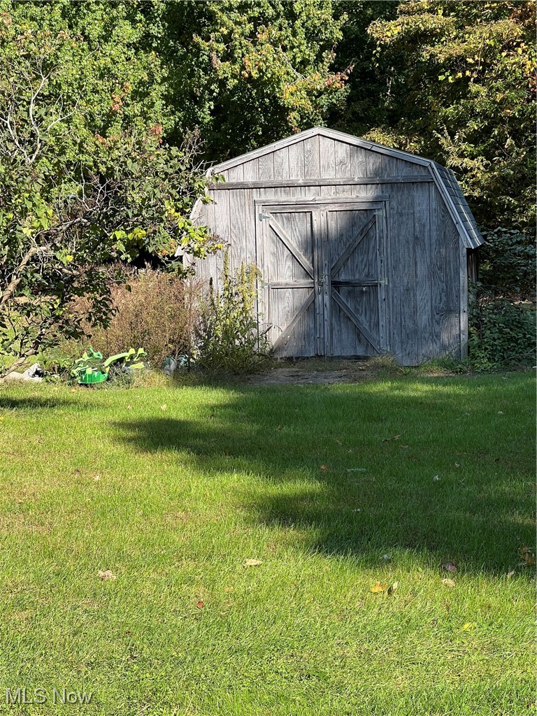 View of outbuilding featuring a lawn
