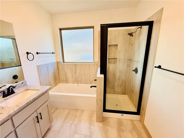 a bathroom with a tub a sink and a mirror