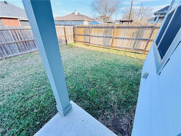 a view of a yard with wooden fence