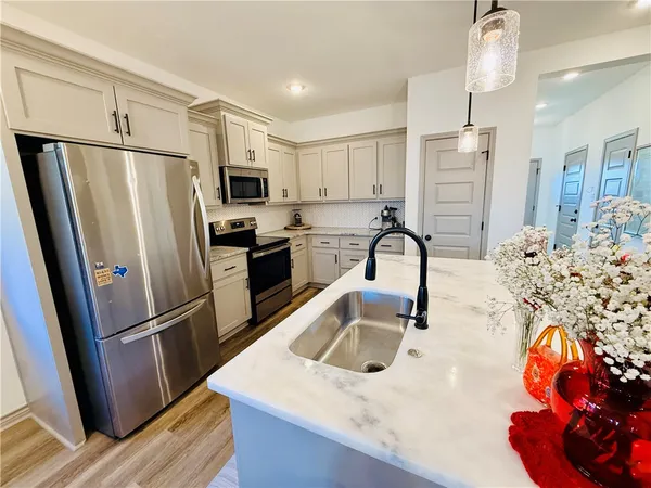 a kitchen with stainless steel appliances granite countertop a refrigerator and a sink