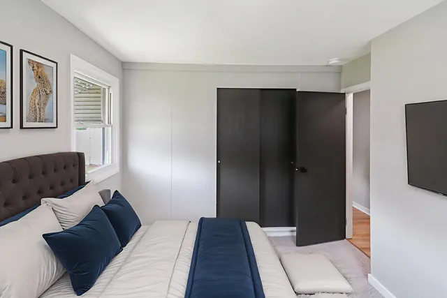 a bedroom with a bed and a flat tv screen