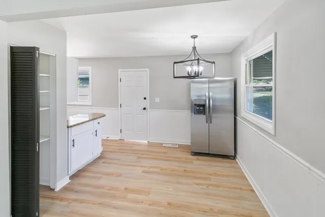 a large kitchen with a refrigerator a sink and cabinets